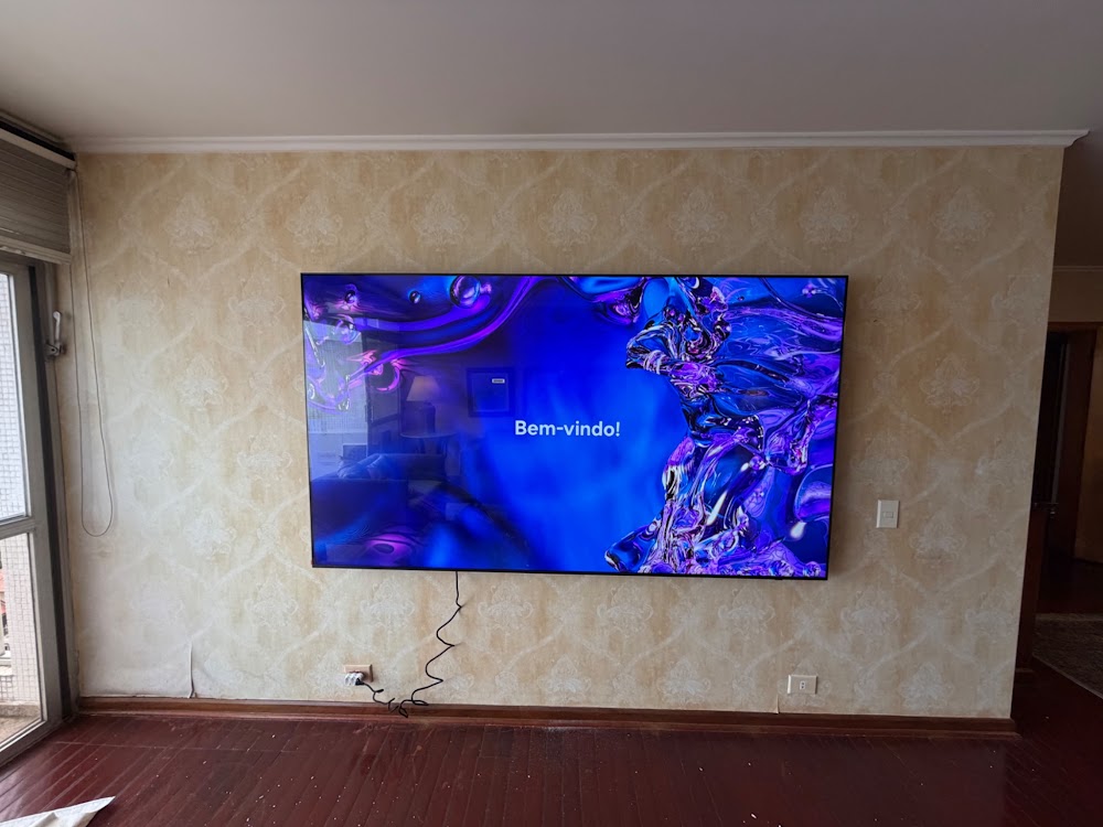 Televisor instalado em uma parede com acabamento texturizado